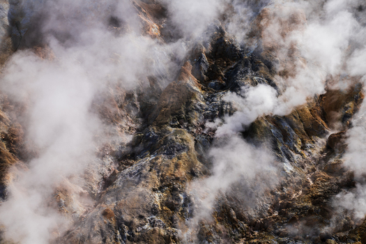 View of geothermal landscape where steam rises from the earth creating an ethereal haze over the rugged terrain a dance of earth and sky Hrunamannahreppur Iceland.