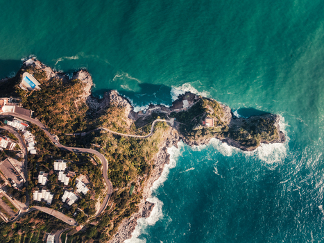 Aerial view of the rugged coastline where the cliffs meet the turquoise sea showcasing a winding road and seaside villas Amalfi Campania Italy. Aerial view of the rugged coastline where the cliffs meet the turquoise sea showcasing a winding road and seaside villas Amalfi Campania Italy.