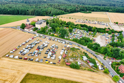 Aerial view of Schloss Jagersburg with a large parking area filled with cars and campers surrounded by green fields and forests in Eggolsheim Bayern Germany. Aerial view of Schloss Jagersburg with a large parking area filled with cars and campers surrounded by green fields and forests in Eggolsheim Bayern Germany.
