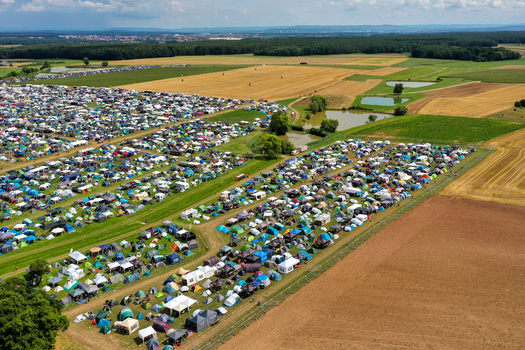 Herzogenaurach Germany 24 July 2025 Aerial view of the Open Beatz Festival campsite featuring thousands of colorful tents spread across vast fields surrounded by forests.
