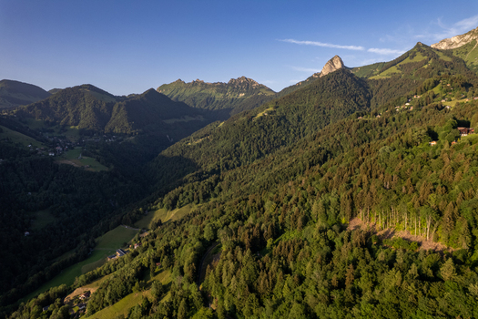 Aerial view of Glion nestled in the lush green mountains near Montreux featuring dense forests steep slopes and rocky peaks under a clear blue sky in Montreux Vaud Switzerland. Aerial view of Glion nestled in the lush green mountains near Montreux featuring dense forests steep slopes and rocky peaks under a clear blue sky in Montreux Vaud Switzerland.