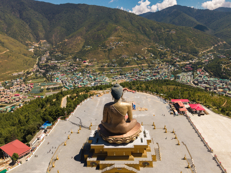 Aerial view of the Great Buddha Dordenma statue overlooking the valley and the city with green mountains in the background Thimphu Bhutan.