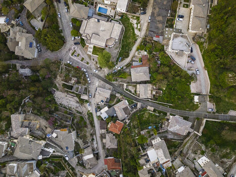 Aerial view of historic stone houses with grey slate roofs narrow winding streets and lush greenery in Gjirokaster Gjirokaster County Albania. Aerial view of historic stone houses with grey slate roofs narrow winding streets and lush greenery in Gjirokaster Gjirokaster County Albania.