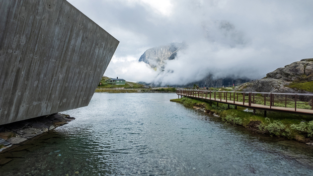 Andalsnes Norway 23 June 2024 View of the Trollstigen visitor center and wooden walkway by a mountain lake under a cloudy sky. Andalsnes Norway 23 June 2024 View of the Trollstigen visitor center and wooden walkway by a mountain lake under a cloudy sky.
