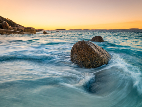 View of Frenchman Bay featuring large granite boulders in the turquoise ocean with smooth wave motion at sunset in Frenchman Bay Western Australia Australia. View of Frenchman Bay featuring large granite boulders in the turquoise ocean with smooth wave motion at sunset in Frenchman Bay Western Australia Australia.