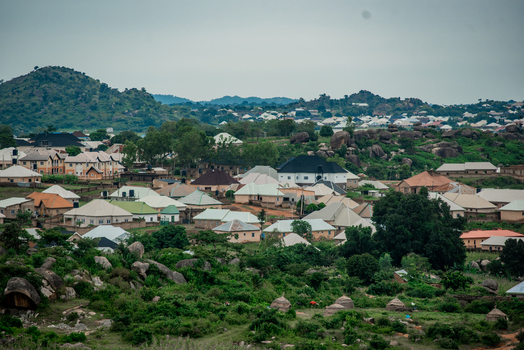 View of residential houses nestled among rocky hills and lush greenery in the landscape of Jos North Plateau Nigeria. View of residential houses nestled among rocky hills and lush greenery in the landscape of Jos North Plateau Nigeria.