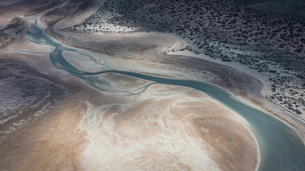 Aerial view of abstract patterns formed by turquoise blue water and brown sands along the coastline in Useless Loop Western Australia Australia. Aerial view of abstract patterns formed by turquoise blue water and brown sands along the coastline in Useless Loop Western Australia Australia.