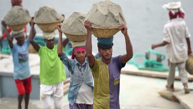View of workers carrying sand baskets in Aminbazar Bangladesh. View of workers carrying sand baskets in Aminbazar Bangladesh.