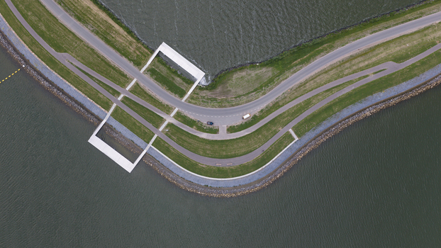 Aerial view of a modern architectural structure integrated into the dike path along the water in Uitdam North Holland Netherlands.