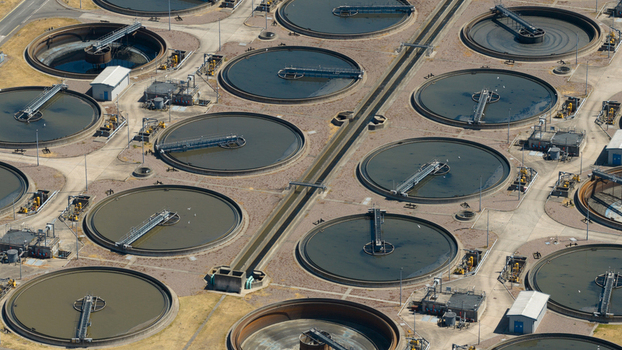 Aerial view of the Severn Trent Water Minworth sewage treatment works featuring large circular sedimentation tanks and industrial infrastructure in Birmingham England United Kingdom. Aerial view of the Severn Trent Water Minworth sewage treatment works featuring large circular sedimentation tanks and industrial infrastructure in Birmingham England United Kingdom.