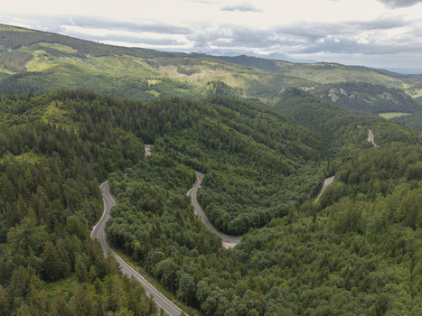 Aerial view of the winding Vernarske Chvalabohu mountain road surrounded by dense green forests and rolling hills in Vernar Presovsky kraj Slovakia. Aerial view of the winding Vernarske Chvalabohu mountain road surrounded by dense green forests and rolling hills in Vernar Presovsky kraj Slovakia.
