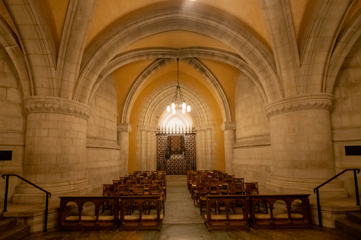 Washington District of Columbia United States 06 May 2025 View of the Washington National Cathedral interior with stone vaulted ceilings wooden chairs and a metal gate.