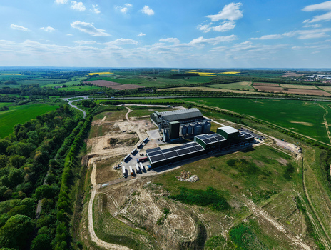 Aerial view of the Oat Milling Factory featuring industrial buildings with solar panels and storage silos surrounded by green fields Kettering England United Kingdom. Aerial view of the Oat Milling Factory featuring industrial buildings with solar panels and storage silos surrounded by green fields Kettering England United Kingdom.