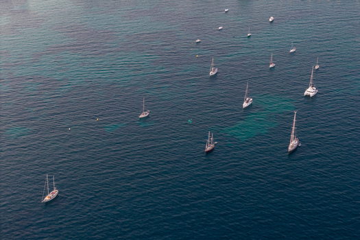 Aerial view of sailboats anchored in the turquoise waters of the Mediterranean Sea off the coast of Antibes Provence Alpes Cote d Azur France. Aerial view of sailboats anchored in the turquoise waters of the Mediterranean Sea off the coast of Antibes Provence Alpes Cote d Azur France.