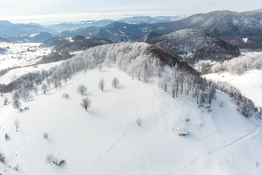 Brasov Romania 21 September 2026 Aerial view of a snow covered landscape featuring frost covered trees rolling hills and a small cabin in the winter scenery. Brasov Romania 21 September 2026 Aerial view of a snow covered landscape featuring frost covered trees rolling hills and a small cabin in the winter scenery.