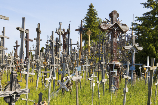 View of the Hill of Crosses featuring thousands of wooden and metal crucifixes standing on a grassy slope under a clear blue sky in Siauliu Siauliu apskritis Lithuania. View of the Hill of Crosses featuring thousands of wooden and metal crucifixes standing on a grassy slope under a clear blue sky in Siauliu Siauliu apskritis Lithuania.
