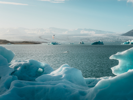 Aerial view of Jokulsarlon glacier lagoon with floating icebergs and a kite surfer in the water Sveitarfelagid Hornafjordur Iceland. Aerial view of Jokulsarlon glacier lagoon with floating icebergs and a kite surfer in the water Sveitarfelagid Hornafjordur Iceland.