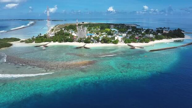 Aerial view of Thulusdhoo island and coral reefs Maldives.
