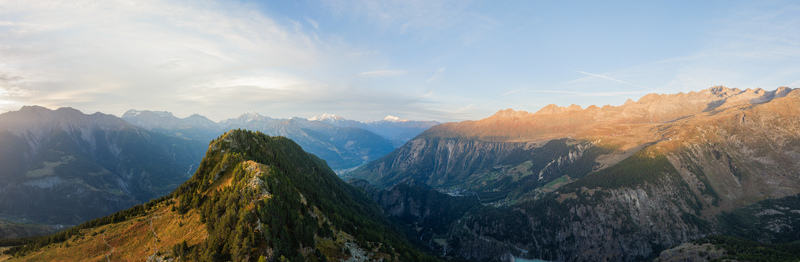 Aerial view of Aletsch Glacier region with dramatic mountain peaks coniferous forests and a deep valley illuminated by golden hour light in Fieschertal Valais Switzerland. Aerial view of Aletsch Glacier region with dramatic mountain peaks coniferous forests and a deep valley illuminated by golden hour light in Fieschertal Valais Switzerland.