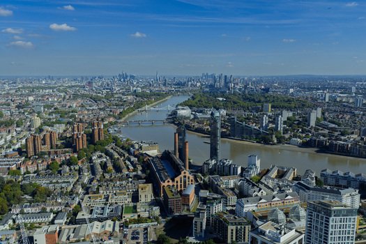 Aerial view of Lots Road Power Station on the banks of the River Thames with the city skyline in the distance London England United Kingdom. Aerial view of Lots Road Power Station on the banks of the River Thames with the city skyline in the distance London England United Kingdom.