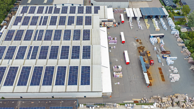 Aerial view of the Boekelermeer industrial facility with a large solar panel roof trucks in the loading yard and pallets of goods in Alkmaar Noord Holland Netherlands.