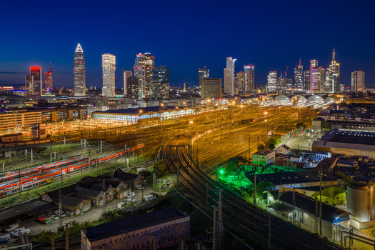 Aerial view of Hauptbahnhof with illuminated train tracks and the modern skyscraper skyline under a twilight sky in Frankfurt am Main Hessen Germany.