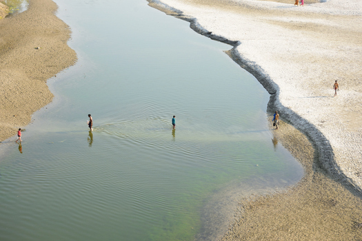 Kushtia District Khulna Division Bangladesh 10 March 2020 View of people wading through the shallow waters of a calm river with sandy banks. Kushtia District Khulna Division Bangladesh 10 March 2020 View of people wading through the shallow waters of a calm river with sandy banks.