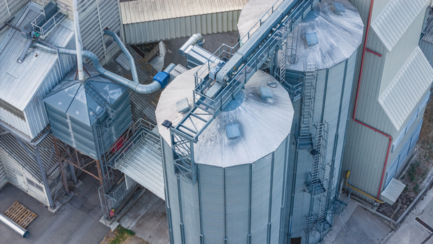 Aerial view of galvanized grain silos conveyor bridges and processing equipment at a modern agricultural storage facility in Le Pouzin Auvergne Rhone Alpes France.