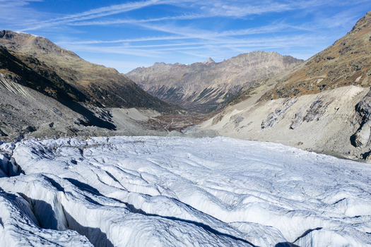 Aerial view of the glacial ice stretching out under a clear blue sky framed by rugged mountainsides Morteratsch Glacier Grisons Switzerland. Aerial view of the glacial ice stretching out under a clear blue sky framed by rugged mountainsides Morteratsch Glacier Grisons Switzerland.