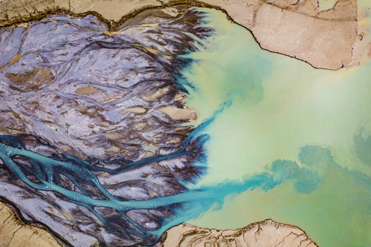Aerial view of the river delta near Prutz featuring intricate sediment patterns and vibrant turquoise glacial water flowing into a larger body of water in Prutz Tyrol Austria. Aerial view of the river delta near Prutz featuring intricate sediment patterns and vibrant turquoise glacial water flowing into a larger body of water in Prutz Tyrol Austria.