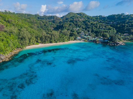 Aerial view of turquoise waters meet the white sandy beach fringed with lush green tropical forest Victoria Seychelles. Aerial view of turquoise waters meet the white sandy beach fringed with lush green tropical forest Victoria Seychelles.