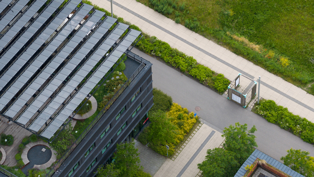 Aerial view of a modern building featuring solar panels and a lush green roof with sedum and vegetation for sustainable urban design in Almere Flevoland Netherlands. Aerial view of a modern building featuring solar panels and a lush green roof with sedum and vegetation for sustainable urban design in Almere Flevoland Netherlands.