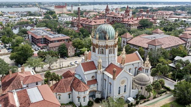Aerial view of Memorial Presbyterian Church with its distinctive copper dome and terracotta roof surrounded by historic buildings in St. Augustine Florida United States.