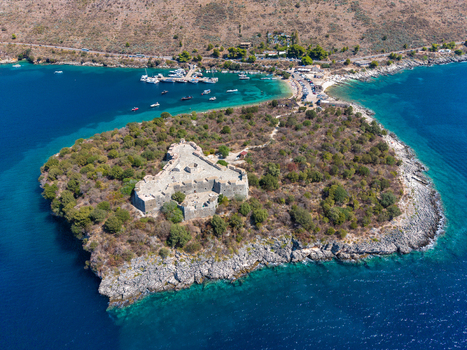 Aerial view of The Castle of Porto Palermo situated on a peninsula surrounded by turquoise waters rocky coastlines and lush Mediterranean vegetation in Porto Palermo Qarku i Vlores Albania.