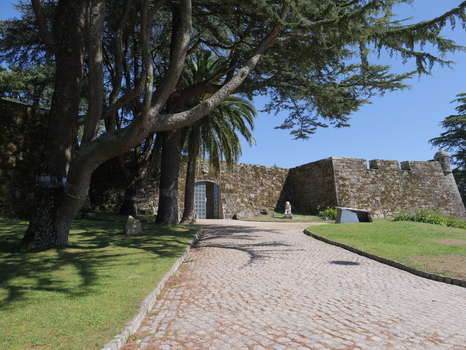 View of Castelo do Castro with its historic stone walls cobblestone path and surrounding trees under a clear blue sky in Vigo Pontevedra Spain.