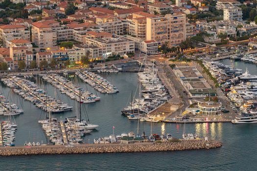 Aerial view of the marina in Antibes filled with numerous yachts and boats surrounded by urban buildings and coastal infrastructure in Antibes Provence Alpes Cote d Azur France. Aerial view of the marina in Antibes filled with numerous yachts and boats surrounded by urban buildings and coastal infrastructure in Antibes Provence Alpes Cote d Azur France.