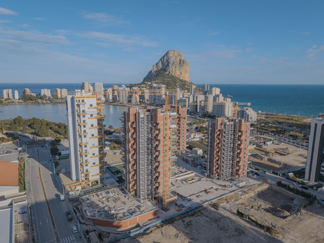 Aerial view of high rise buildings under construction with tower cranes near the coast with the Penyal d Ifac landmark in the background in Calp Valencian Community Spain. Aerial view of high rise buildings under construction with tower cranes near the coast with the Penyal d Ifac landmark in the background in Calp Valencian Community Spain.