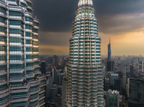 Kuala Lumpur Malaysia 11 March 2026 Aerial view of the Petronas Twin Towers under a dramatic sunset sky with the city skyline in the background.