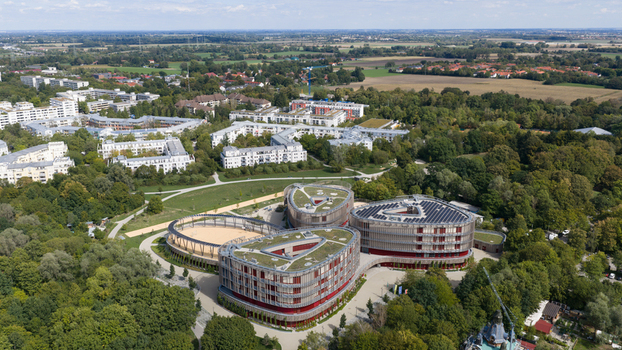 Durmersheim Baden Wuerttemberg Germany 12 September 2026 Aerial view of Wilhelm Hausenstein Gymnasium featuring modern triangular architecture with green roofs and solar panels surrounded by lush trees.
