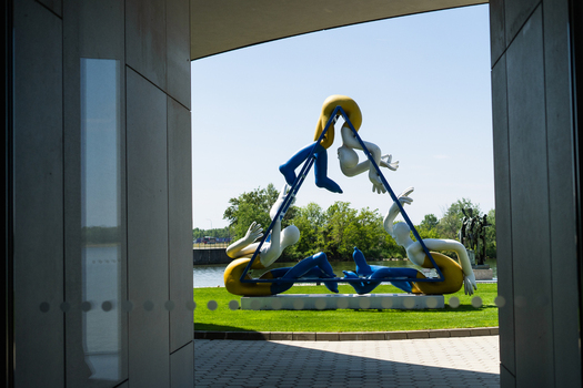 Bratislava Slovakia 09 May 2026 View of a modern sculpture of colorful human figures in a triangular frame at the Danubiana Meulensteen Art Museum park by the Danube river.