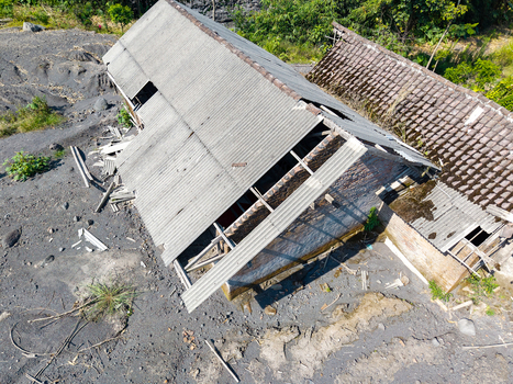 Aerial view of a damaged house in Supiturang Village covered in volcanic ash following the catastrophic eruption of Mount Semeru in Pronojiwo East Java Indonesia.