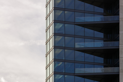 View of a modern glass skyscraper facade with balconies and steel framing in London England United Kingdom.