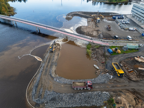 Oulu Finland 18 September 2026 Aerial view of a construction site at the waterfront featuring heavy machinery a bridge spanning the river and earthworks along the shoreline. Oulu Finland 18 September 2026 Aerial view of a construction site at the waterfront featuring heavy machinery a bridge spanning the river and earthworks along the shoreline.