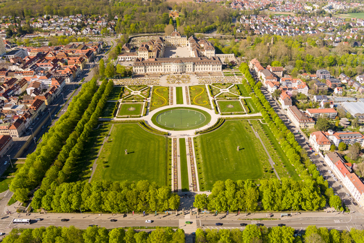 Aerial view of the baroque Ludwigsburg Palace surrounded by meticulously manicured gardens tree lined paths and the urban landscape of Ludwigsburg Baden Wurttemberg Germany.