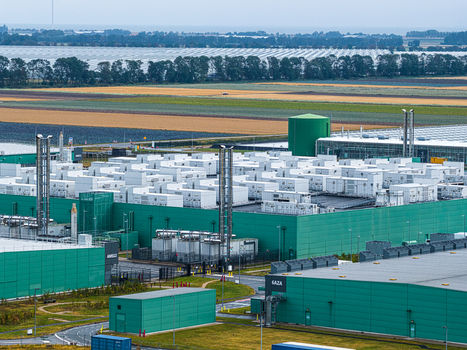 Aerial view of the Agriport A7 data center facility featuring large green industrial buildings cooling units and surrounding agricultural fields in Middenmeer Noord Holland Netherlands. Aerial view of the Agriport A7 data center facility featuring large green industrial buildings cooling units and surrounding agricultural fields in Middenmeer Noord Holland Netherlands.