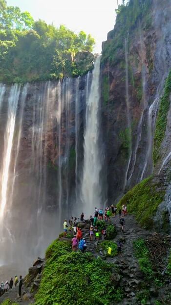 Aerial view of Tumpak Sewu Waterfall with tourists Indonesia.