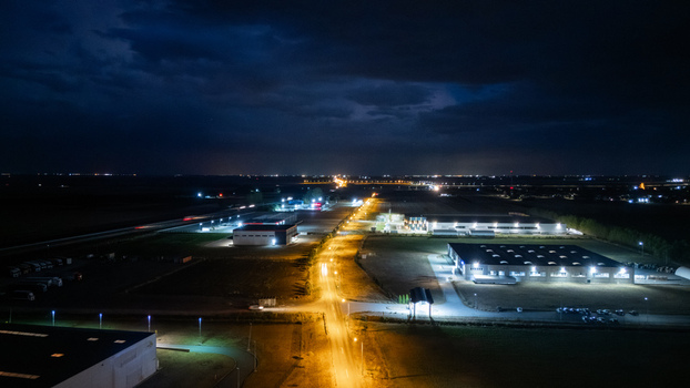 Aerial view of an industrial zone in Sremska Mitrovica at night featuring illuminated warehouses street lighting and a dark sky in Sremska Mitrovica Vojvodina Serbia. Aerial view of an industrial zone in Sremska Mitrovica at night featuring illuminated warehouses street lighting and a dark sky in Sremska Mitrovica Vojvodina Serbia.