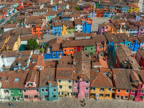 Aerial view of a vibrant patchwork of houses with terracotta roofs creates a stunning mosaic of color against the blue sky Burano Veneto Italy. Aerial view of a vibrant patchwork of houses with terracotta roofs creates a stunning mosaic of color against the blue sky Burano Veneto Italy.
