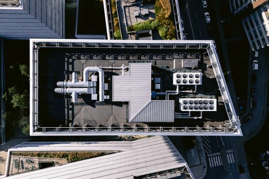 Aerial view of a modern building rooftop featuring industrial HVAC systems ventilation ducts and cooling units in Vilnius Vilnius County Lithuania.