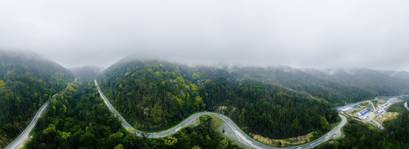 Aerial view of winding roads carve through emerald forests disappearing into the misty embrace of the hills Novi Sad Vojvodina Serbia. Aerial view of winding roads carve through emerald forests disappearing into the misty embrace of the hills Novi Sad Vojvodina Serbia.